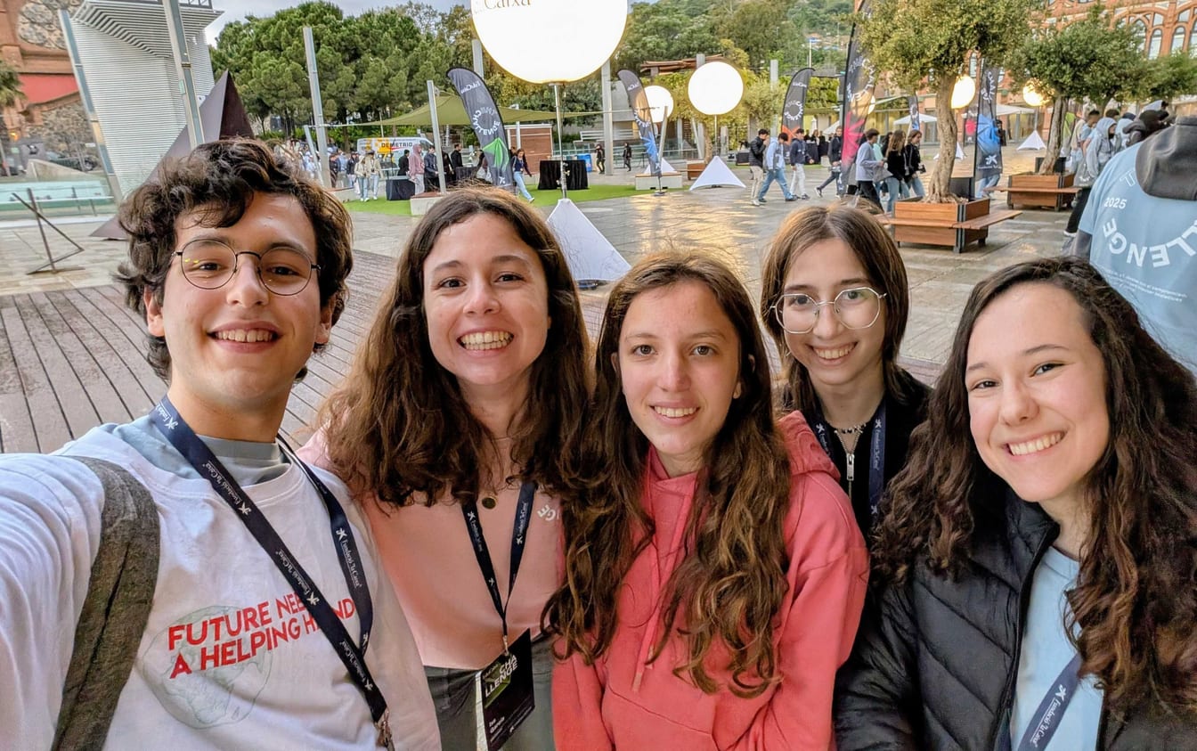 Daniel Negre and teammates smile together outdoors at The Challenge 2025 in Barcelona.