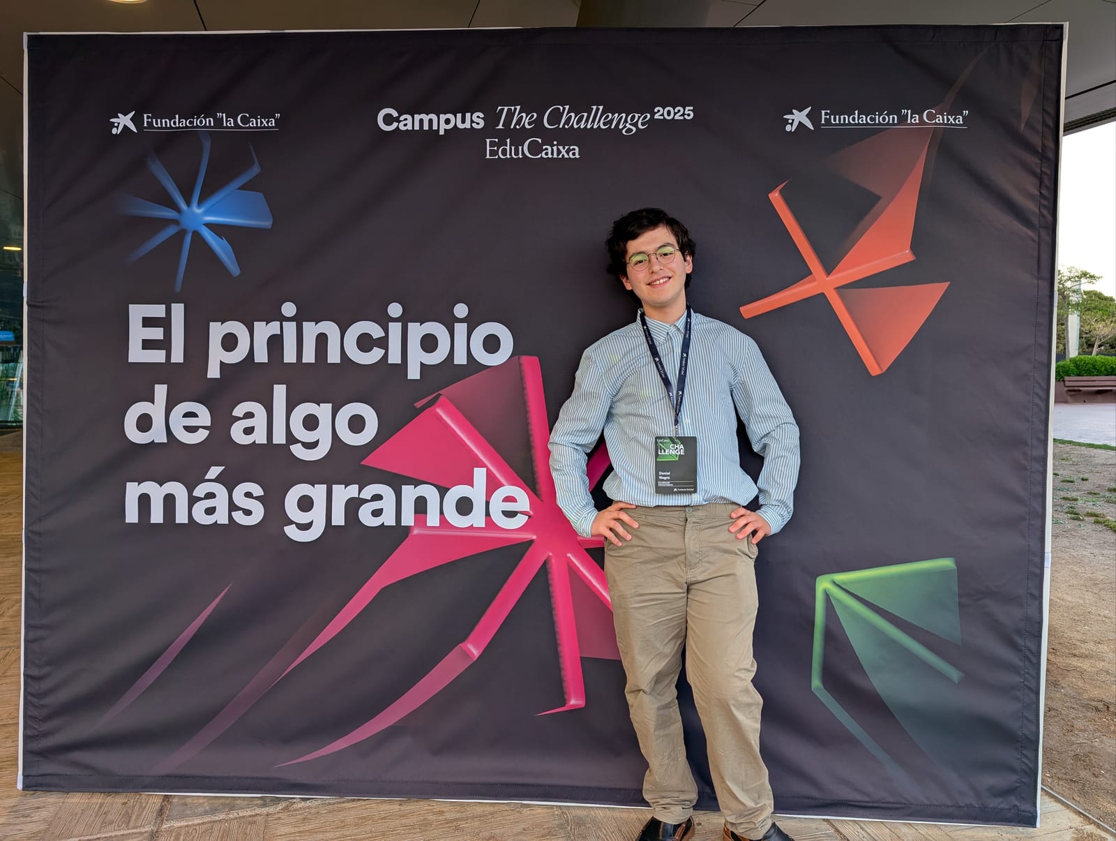 Daniel Negre stands at the Campus The Challenge 2025 EduCaixa photo backdrop.